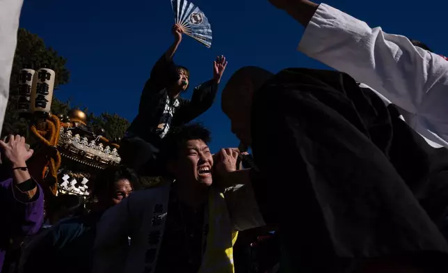 Participants carry a portable shrine 'mikoshi', during the Winter Sea Misogi Festival, a Shinto purification ritual marking the New Year, in Numazu, Japan, Monday, Jan. 12, 2026. (AP Photo/Louise Delmotte)