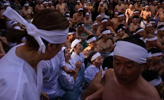 Participants bathe in ice-cold water to purify their souls and pray for good health during a New Year's ritual at Teppozu Inari Shrine in Tokyo, Sunday, Jan. 11, 2026. (AP Photo/Louise Delmotte)