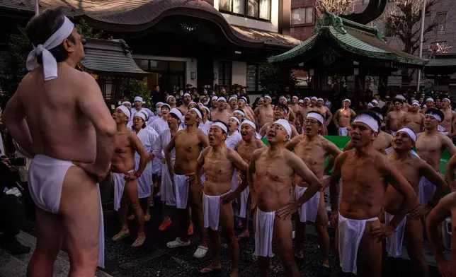 Participants pray after bathing in ice-cold water to purify their souls and wish for good health during a New Year ritual at Teppozu Inari Shrine in Tokyo, Sunday, Jan. 11, 2026. (AP Photo/Louise Delmotte)