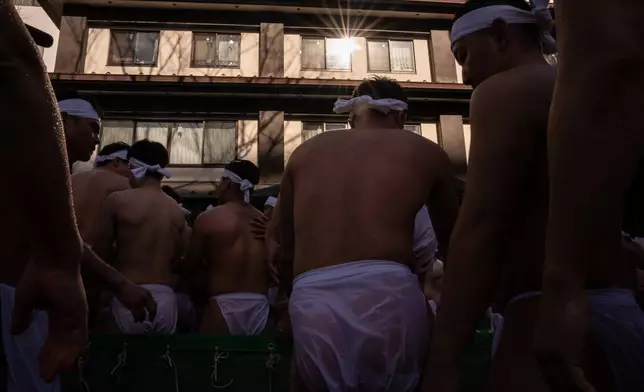 Participants bathe in ice-cold water to purify their souls and pray for good health during a New Year's ritual at Teppozu Inari Shrine in Tokyo, Sunday, Jan. 11, 2026. (AP Photo/Louise Delmotte)