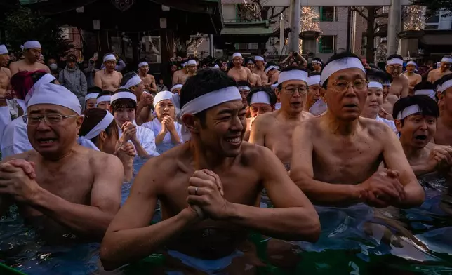 Participants bathe in ice-cold water to purify their souls and pray for good health during a New Year's ritual at Teppozu Inari Shrine in Tokyo, Sunday, Jan. 11, 2026. (AP Photo/Louise Delmotte)
