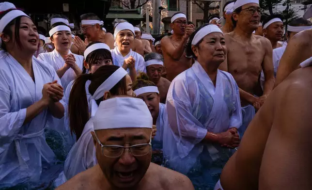 Participants bathe in ice-cold water to purify their souls and pray for good health during a New Year's ritual at Teppozu Inari Shrine in Tokyo, Sunday, Jan. 11, 2026. (AP Photo/Louise Delmotte)