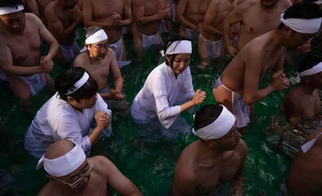 Participants bathe in ice-cold water to purify their souls and pray for good health during a New Year's ritual at Teppozu Inari Shrine in Tokyo, Sunday, Jan. 11, 2026. (AP Photo/Louise Delmotte)
