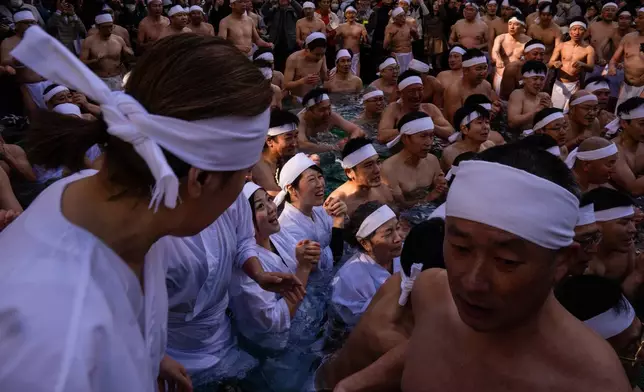 Participants bathe in ice-cold water to purify their souls and pray for good health during a New Year's ritual at Teppozu Inari Shrine in Tokyo, Sunday, Jan. 11, 2026. (AP Photo/Louise Delmotte)