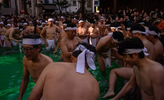 Participants bathe in ice-cold water to purify their souls and pray for good health during a New Year's ritual at Teppozu Inari Shrine in Tokyo, Sunday, Jan. 11, 2026. (AP Photo/Louise Delmotte)