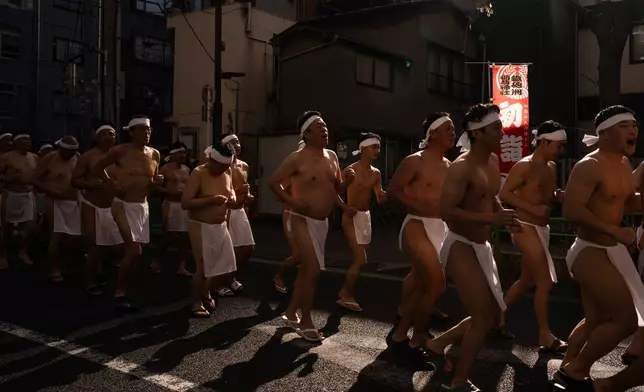 Participants prepare to bathe in ice-cold water to purify their souls and pray for good health during a New Year's ritual at Teppozu Inari Shrine in Tokyo, Sunday, Jan. 11, 2026. (AP Photo/Louise Delmotte)