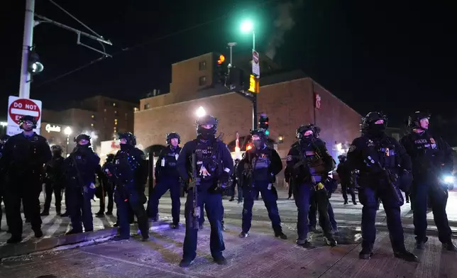 Law enforcement officers prepare to make arrests after declaring an unlawful assembly during a noise demonstration outside the Graduate by Hilton Minneapolis hotel on Wednesday, Jan. 28, 2026, in Minneapolis. (AP Photo/Adam Gray)