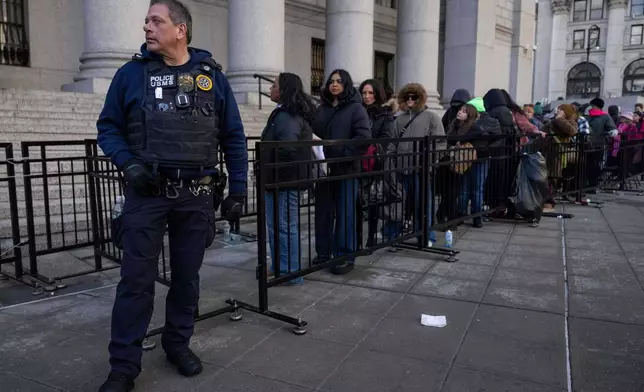US Marshall Service officer stand while people wait in line outside Manhattan federal court ahead of a hearing for Luigi Mangione, Friday, Jan. 9, 2026, in New York. (AP Photo/Yuki Iwamura)