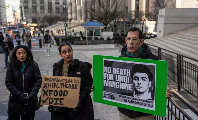 Supporters of Luigi Mangione raise signs outside Manhattan federal court, Friday, Jan. 9, 2026, in New York. (AP Photo/Yuki Iwamura)