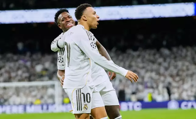 Real Madrid's Kylian Mbappe celebrates with Vinicius Junior the opening goal during the Champions League opening phase soccer match between Real Madrid and Monaco in Madrid on Tuesday, Jan. 20, 2026. (AP Photo/Jose Breton)