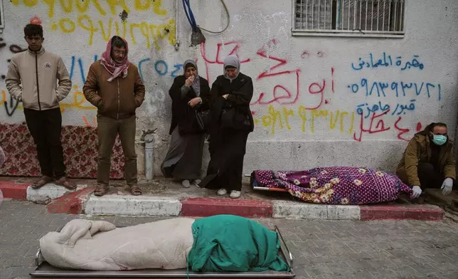 Members of the Hamouda family bid farewell to relatives who died when a damaged building collapsed onto their tents during a storm of wind and rain, at Al-Shifa Hospital in Gaza City, Tuesday, Jan. 13, 2026. (AP Photo/Jehad Alshrafi)