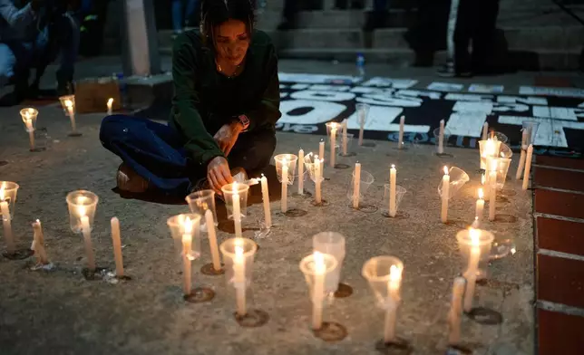 Francy Fernandez lights a candle during a vigil calling for her husband, Carlos Julio Rojas, to be set free outside El Helicoide, the headquarters of Venezuela's intelligence service and detention center, in Caracas, Venezuela, Friday, Jan. 9, 2026 after the government announced prisoners would be released.(AP Photo/Ariana Cubillos)