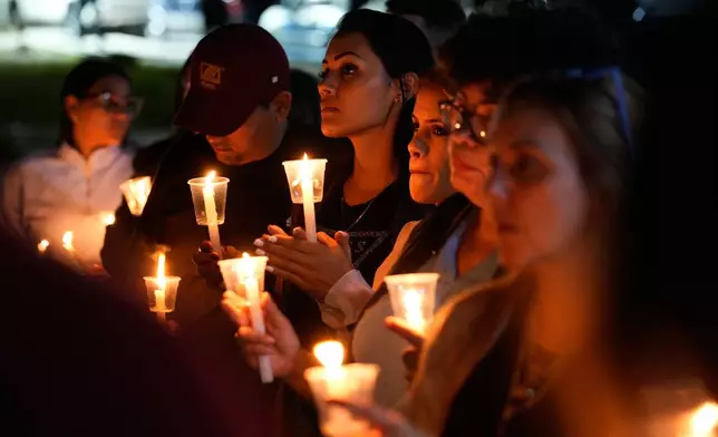 Shakira Ibarreto, center, holds a candle calling for her father Miguel Ibarreto to be set free outside the Rodeo I prison in Guatire, Venezuela, Friday, Jan. 9, 2026 after the government announced prisoners would be released. (AP Photo/Matias Delacroix)