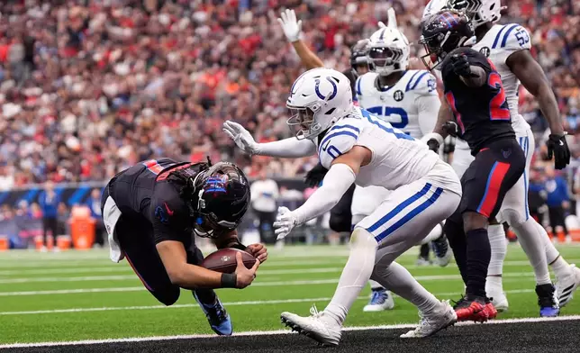 Houston Texans quarterback C.J. Stroud (7) dives past Indianapolis Colts safety Cam Bynum (0) for a touchdown during the first half of an NFL football game in Houston, Sunday, Jan. 4, 2026. (AP Photo/Ashley Landis)