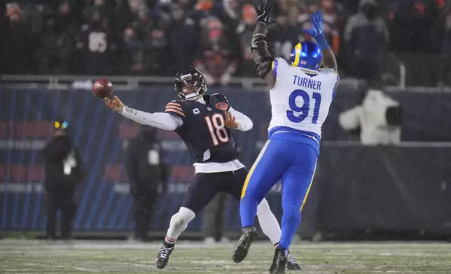 Chicago Bears quarterback Caleb Williams (18) throws a pass as Los Angeles Rams defensive end Kobie Turner (91) applies pressure during the second half of an NFL football divisional playoff game Sunday, Jan. 18, 2026, in Chicago. (AP Photo/Jeff Roberson)