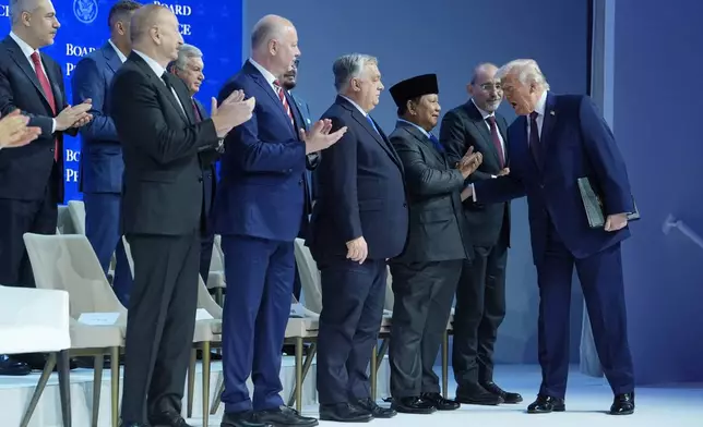 President Donald Trump, right, greets leaders as he arrives for a Board of Peace charter announcement during the Annual Meeting of the World Economic Forum in Davos, Switzerland, Thursday, Jan. 22, 2026. (AP Photo/Evan Vucci)