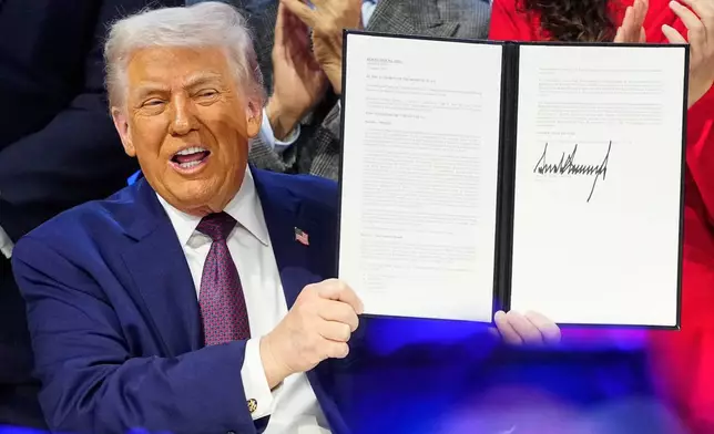 President Donald Trump holds the charter during a signing ceremony on his Board of Peace initiative at the Annual Meeting of the World Economic Forum in Davos, Switzerland, Thursday, Jan. 22, 2026. (AP Photo/Markus Schreiber)