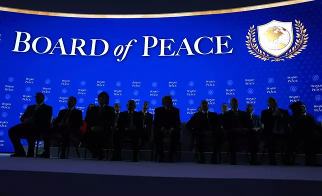 President Donald Trump, center, sits on stage with international leaders after the signing of a Board of Peace charter during the Annual Meeting of the World Economic Forum in Davos, Switzerland, Thursday, Jan. 22, 2026. (AP Photo/Evan Vucci)