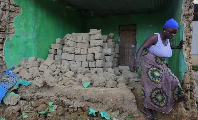 Hawa Manubah, a mother of 13, leaves the ruins of her former home, which she says was damaged by concussions from mining explosives, in Gold Camp, Liberia. "We were in the house when we heard the blasting sound-boom, and everyone ran away," she said on July 8, 2025. (AP Photo/Misper Apawu)