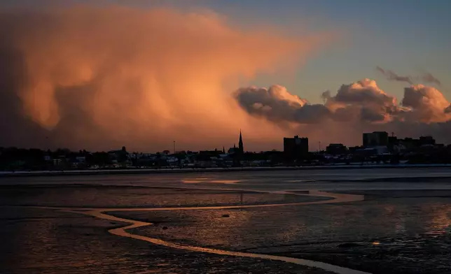 Storm clouds that had brought brief snow flurries begin to clear, Tuesday, Jan. 20, 2026, over Portland, Maine. (AP Photo/Robert F. Bukaty)