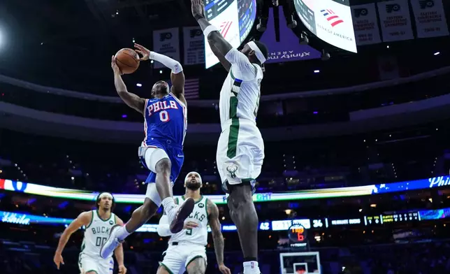 Philadelphia 76ers' Tyrese Maxey, left, goes up for a shot against Milwaukee Bucks' Bobby Portis during the first half of an NBA basketball game Tuesday, Jan. 27, 2026, in Philadelphia. (AP Photo/Matt Slocum)