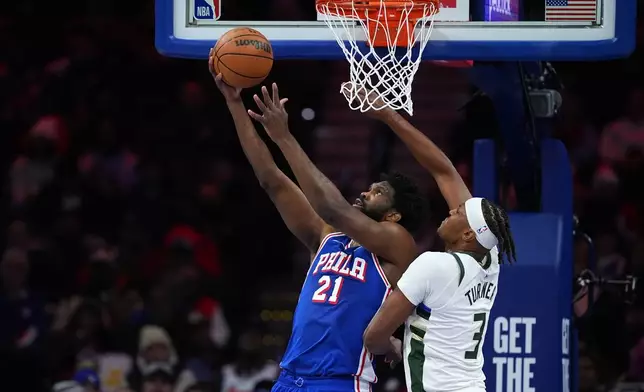 Philadelphia 76ers' Joel Embiid, left, goes up for a shot against Milwaukee Bucks' Myles Turner during the first half of an NBA basketball game Tuesday, Jan. 27, 2026, in Philadelphia. (AP Photo/Matt Slocum)