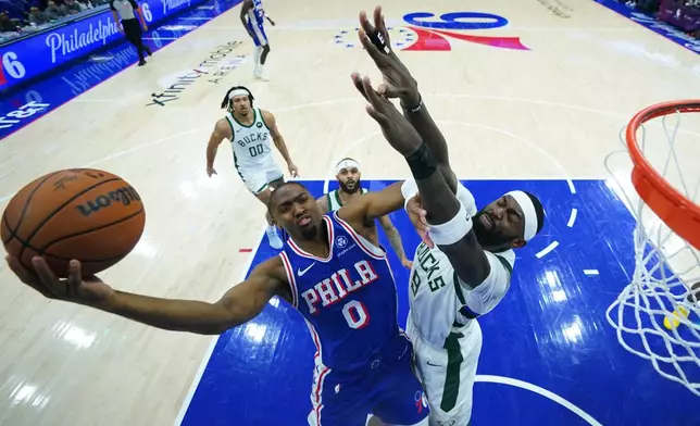 Philadelphia 76ers' Tyrese Maxey, left, goes up for a shot against Milwaukee Bucks' Bobby Portis during the first half of an NBA basketball game Tuesday, Jan. 27, 2026, in Philadelphia. (AP Photo/Matt Slocum)