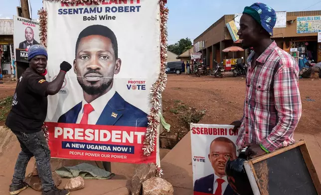 A supporter of Uganda opposition presidential candidate Robert Kyagulanyi Ssentamu, known as Bobi Wine, holds onto a campaign poster in Kampala, Uganda, Tuesday, Jan. 13, 2026. (AP Photo/Hajarah Nalwadda)
