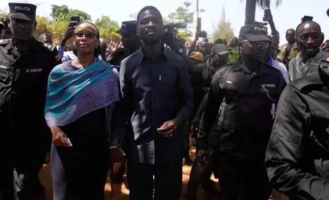 Uganda opposition presidential candidate Robert Kyagulanyi Ssentamu, famously known as Bobi Wine of the National Unity Platform (NUP), arrives with his wife to cast their votes, during the presidential election at a polling station, in Kampala, Uganda, Thursday, Jan. 15, 2026. (AP Photo/Brian Inganga)