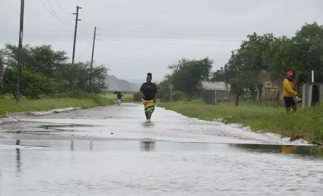 People walk through floodwaters in Nkomazi, Mpumalanga Province, South Africa, on Friday, Jan. 16, 2026. (AP Photo/Alfonso Nqunjana)