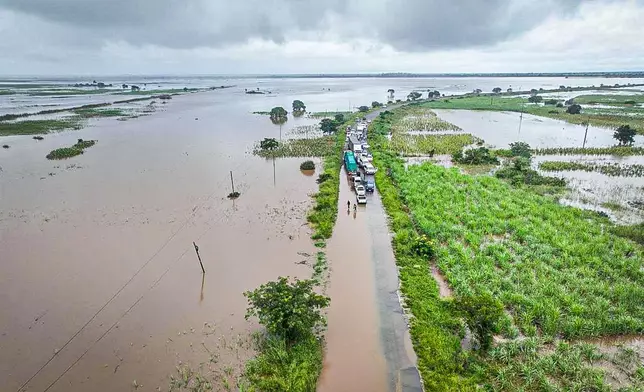 Vehicles lineup the flood-damaged N1 road in Maputo province road, Mozambique, Saturday, Jan. 17, 2026. (AP Photo)
