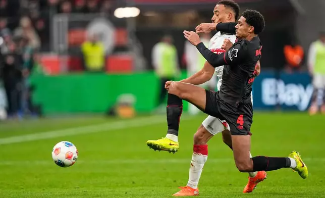Leverkusen's Jarell Quansah, right, challenges for the ball with Stuttgart's Jamie Leweling during the German Bundesliga soccer match between Bayer 04 Leverkusen and VfB Stuttgart in Leverkusen, Germany, Saturday, Jan. 10, 2026. (AP Photo/Martin Meissner)
