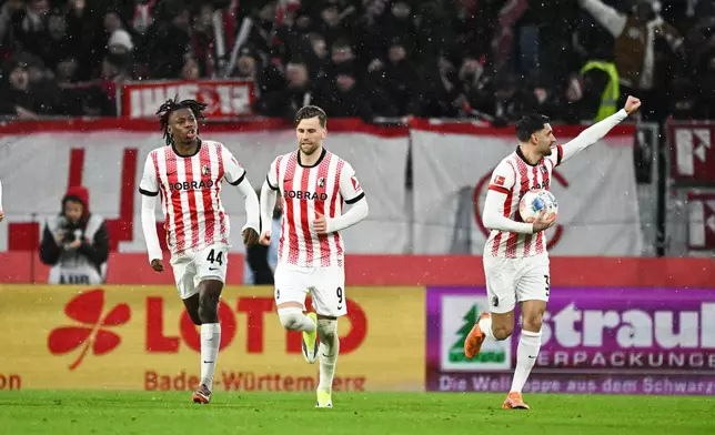 Freiburg players celebrate after scoring during the Bundesliga soccer match between Freiburg and Hamburger, in Freiburg im Breisgau, Germany, Saturday Jan. 10, 2026. (Silas Stein/dpa via AP)