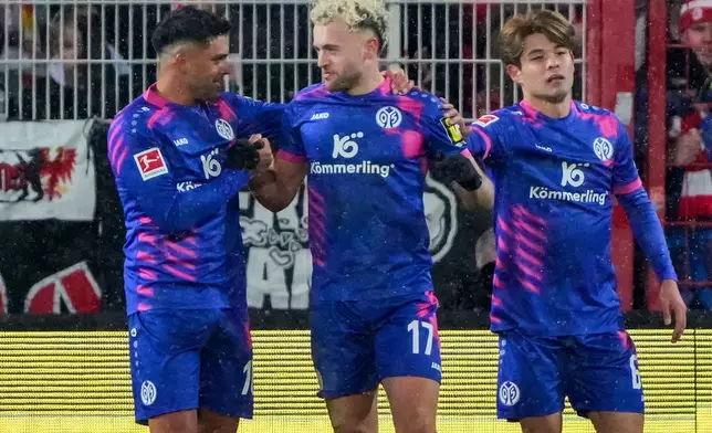 Mainz's Benedict Hollerbach, center, celebrates scoring with teammates Nadiem Amiri, left, and Kaishu Sano during the Bundesliga soccer match between FC Union Berlin and FSV Mainz 05 in Berlin, Saturday Jan. 10, 2026. (Soeren Stache/dpa via AP)