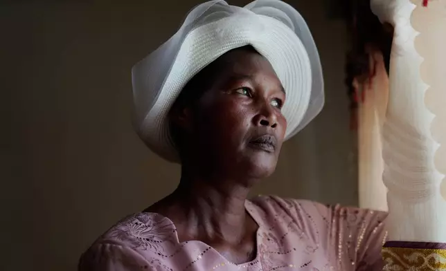 Anne Bonareri, a widow, looks out the window of her home in Kisii, Kenya, Wednesday, Nov. 26, 2025. (AP Photo/Brian Inganga)