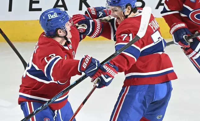 Montreal Canadiens' Jake Evans (71) celebrates with teammate Cole Caufield (13) after scoring against the Vegas Golden Knights during overtime in an NHL hockey game in Montreal, Tuesday, Jan. 27, 2026. (Graham Hughes/The Canadian Press via AP)