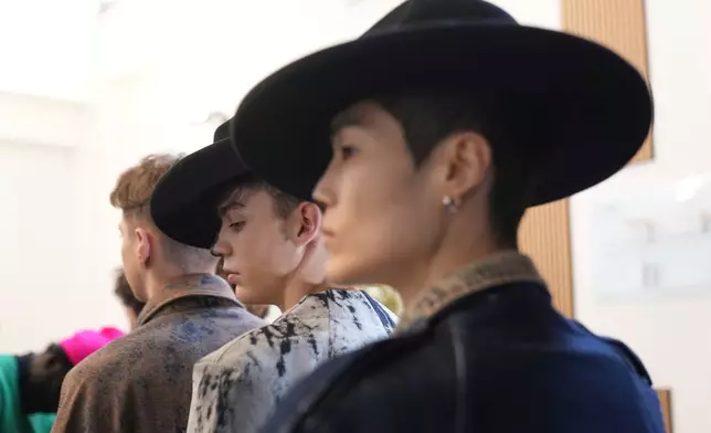 Models get ready in the backstage of the Victor Hart Fall/Winter 2026-2027 Men's fashion show presented in Milan, Italy, Jan. 18, 2026. (AP Photo/Antonio Calanni)