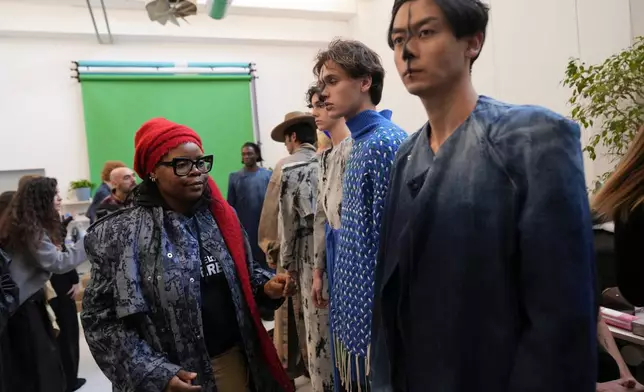 Afro Fashion Association founder Michelle Ngonmo prepares models in the backstage of the Victor-Hart Fall/Winter 2026-2027 Men's fashion show presented in Milan, Italy, Jan. 18, 2026. (AP Photo/Antonio Calanni)