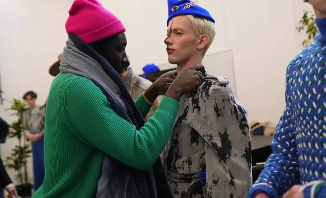 Ghanaian-born fashion designer Victor Reginald Bob Abbey-Hart prepares models backstage at the Victor-Hart Fall/Winter 2026-2027 Men's fashion show in Milan, Italy, Jan. 18, 2026. (AP Photo/Antonio Calanni)