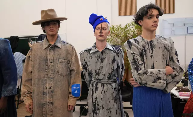 Models get ready in the backstage of the Victor Hart Fall/Winter 2026-2027 Men's fashion show presented in Milan, Italy, Jan. 18, 2026. (AP Photo/Antonio Calanni)