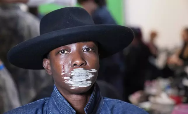 A model poses in the backstage of the Victor Hart Fall/Winter 2026-2027 Men's fashion show presented in Milan, Italy, Jan. 18, 2026. (AP Photo/Antonio Calanni)