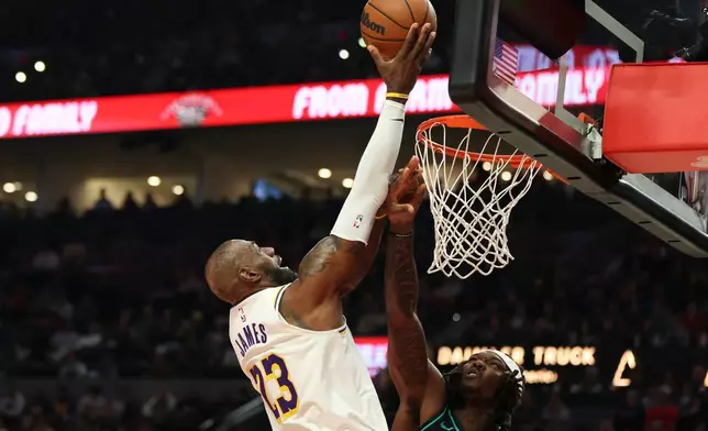 Los Angeles Lakers forward LeBron James (23) drives to the basket as Portland Trail Blazers center Robert Williams III, right, defends during the first half of an NBA basketball game Saturday, Jan. 17, 2026, in Portland, Ore. (AP Photo/Amanda Loman)