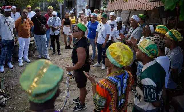 Santeria priests, also known as Babalawos, perform a cleansing ritual with roosters during a ceremony calling for peace and health in Havana, Sunday, Jan. 25, 2026. (AP Photo/Ramon Espinosa)