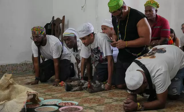 Santeria priests, also known as Babalawos, perform a cleansing ritual with roosters during a ceremony calling for peace and health in Havana, Sunday, Jan. 25, 2026. (AP Photo/Ramon Espinosa)