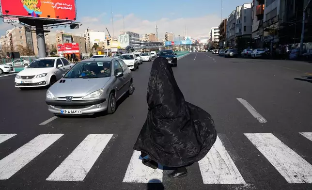 A woman crosses an intersection in downtown Tehran, Iran, Friday, Jan. 16, 2026. (AP Photo/Vahid Salemi)