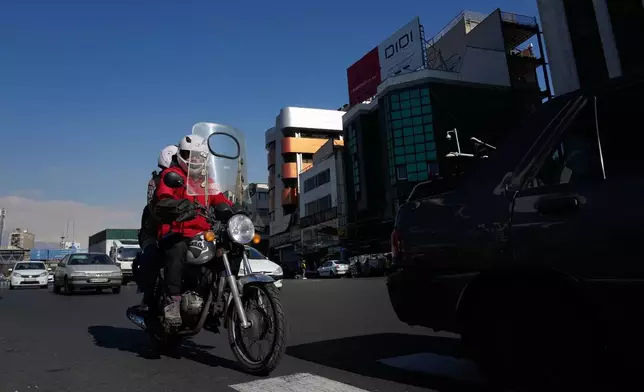 Vehicles drive in downtown Tehran, Iran, Friday, Jan. 16, 2026. (AP Photo/Vahid Salemi)