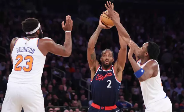 LA Clippers forward Kawhi Leonard (2) looks to pass the ball around New York Knicks center Mitchell Robinson (23) and New York Knicks forward Og Anunoby, right, during the first half of an NBA basketball game, Wednesday, Jan. 7, 2026, in New York. (AP Photo/Heather Khalifa)