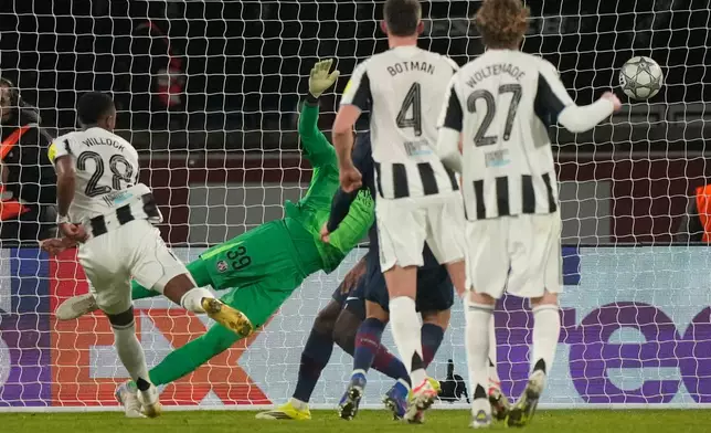 Newcastle's Joe Willock, left, scores his side's opening goal during a Champions League opening phase soccer match between Paris Saint-Germain and Newcastle in Wednesday, Jan. 28, 2026. (AP Photo/Michel Euler)