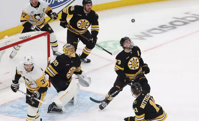 Boston Bruins goaltender Joonas Korpisalo (70) and defenseman Charlie McAvoy (73) watch the puck during the first period of an NHL hockey game against the Pittsburgh Penguins, Sunday, Jan. 11, 2026, in Boston. (AP Photo/Mark Stockwell)
