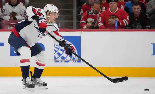 Washington Capitals defenseman Martin Fehérváry (42) shoots the puck as he assists left wing Anthony Beauvillier (72) in scoring a goal on the Chicago Blackhawks during the first period of an NHL hockey game Friday, Jan. 9, 2026, in Chicago. (AP Photo/Erin Hooley)